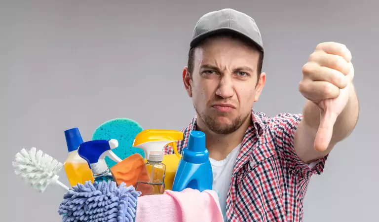 young man with some cleaning products looking unsatisfied